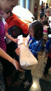 Eleanor giggles while holding a whale's flipper bone.  Well, wouldn't you?